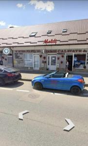 un coche azul estacionado frente a una tienda en Cazare MOLDI - regim hotelier, en Câmpulung Moldovenesc