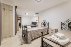 a bedroom with two beds and a bathroom at Room Salento Palace in Torre San Giovanni Ugento