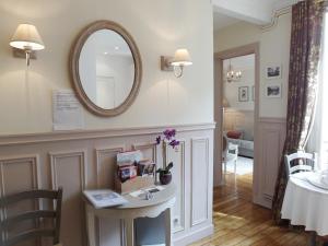 - un salon avec une table et un miroir dans l'établissement Chambre d hôte : Louvre Elegant Apt Suite, à Paris