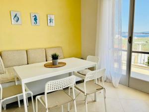 a dining room with a white table and chairs at Holiday House Ermionida in Thermisía