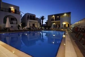 a swimming pool in front of a building at night at Katerina Hotel in Agios Prokopios +60 photos