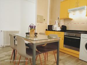 a kitchen with a table and chairs and a dishwasher at Mirador de Zocodover in Toledo