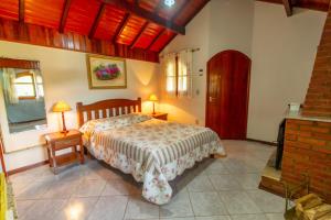 a bedroom with a bed and two lamps on tables at Chales Estrada de Chão in Monte Verde