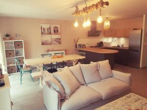 ル・テックにあるMaison SPA proche gare et centre villeの白いソファとキッチンのあるリビングルーム +3枚の写真