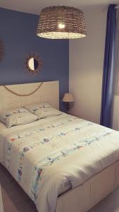 een slaapkamer met een groot bed met een blauwe muur bij Maison SPA proche gare et centre ville in Le Teich