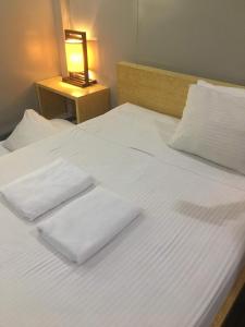 a bed with two white towels on top of it at Homie Sweetie in Morong