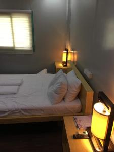 a bedroom with a bed with white sheets and a window at Homie Sweetie in Morong