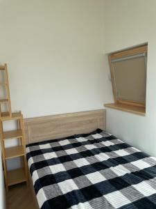 a bedroom with a black and white checkered bed at Smėlėtas krantas in Svencelė