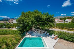 een uitzicht over een zwembad met stoelen en bomen bij Villa Gold Residence 1 in Mlini