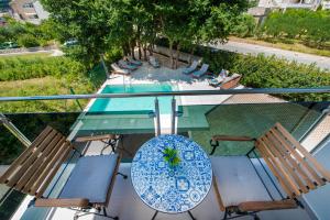 een uitzicht op een tafel en stoelen en een zwembad bij Villa Gold Residence 1 in Mlini