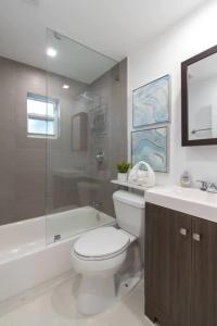 uma casa de banho com um WC, uma banheira e um lavatório. em RENOVATED 2 Bd with Private Hot Tub 6 min to HARDROCK CASINO em Fort Lauderdale
