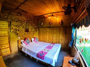 a bedroom with a bed in a wooden cabin at Looc Homestay in Ha Giang +20 photos