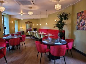 a dining room with tables and red chairs at Hostellerie du Chateau Bellenaves in Bellenaves