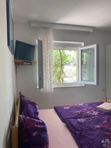 a bedroom with a bed and a window at Guest House Željko Klarić in Skradin