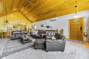 a living room with leather furniture and a wooden ceiling at Lazy Bear Lodge in Sturgis