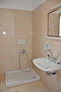 a bathroom with a shower and a sink at Zeus Apartments in Xerokampos