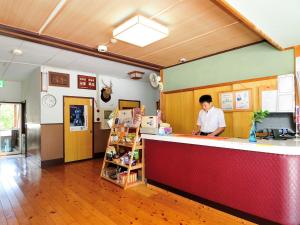 un homme debout à un comptoir dans un magasin dans l'établissement Kami - Hotel / Vacation STAY 15957, à Kami