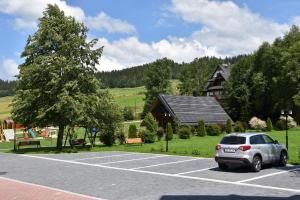 a car parked in a parking lot in front of a house at Pokoje Gościnne Budzowie in Czarna Góra