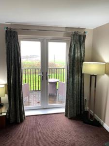 a room with a sliding glass door with a balcony at Ullswater Suite in Penrith