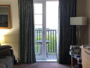 a room with a door open to a balcony at Ullswater Suite in Penrith