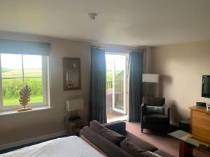 a bedroom with a bed and a couch and a window at Ullswater Suite in Penrith
