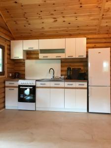 a kitchen with white appliances and a wooden ceiling at Ignaszówka in Radawa
