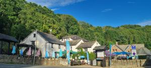a group of buildings with blue umbrellas on a street at The Crumplehorn Inn & Mill in Polperro