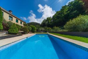 una grande piscina blu in un cortile di SARREN VILLA POOL by Urdaibai Rentals a Bermeo