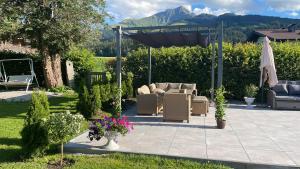 eine Terrasse mit einem Pavillon, Stühlen und Blumen in der Unterkunft Appartementhaus FICHTERN in Sankt Johann in Tirol