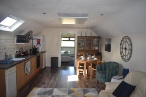 cocina y sala de estar con mesa y sillas en Glens of Antrim apartment, en The Sheddings