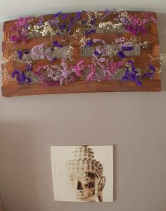 a picture of flowers on a shelf on a wall at Cozy & Quiet Apartment. in Sada