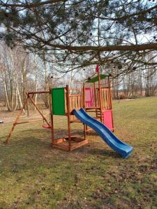 a playground with a slide in a park at Domki u Szreka in Kołczewo
