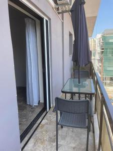 a table and chair with an umbrella on a balcony at Chania Nice Apartment 3 in Chania Town