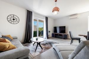 een woonkamer met een bank en een tv bij Villa Gold Residence 1 in Mlini