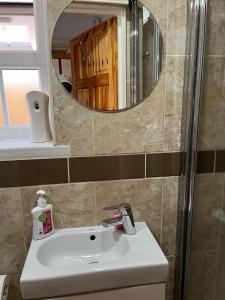a bathroom with a white sink and a mirror at Large Double Bedroom with free on site parking in Kingston upon Thames
