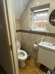 a bathroom with a toilet and a sink and a window at Large Double Bedroom with free on site parking in Kingston upon Thames