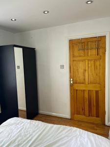 1 dormitorio con 1 cama y puerta de madera en Large Double Bedroom with free on site parking, en Kingston upon Thames