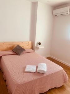 a bedroom with a bed with two towels on it at La Casa de Machado in Cádiz