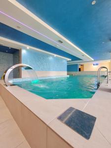 a swimming pool in a hotel with blue water at Goldview Apartmani in Zlatibor