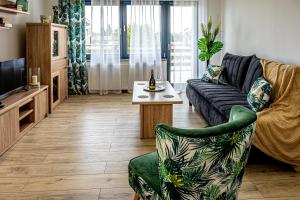 uma sala de estar com um sofá e uma mesa em Apartamenty Na Szlaku 