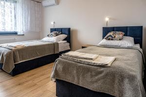 1 dormitorio con 2 camas con mantas en Apartamenty Na Szlaku 