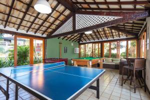 una sala de estar con mesa de ping pong. en Casa em Búzios com vista mar e piscina | EDF 12, en Búzios