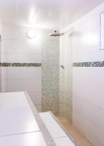 a bathroom with a shower with white tiles at Casa em Búzios com vista mar e piscina | EDF 12 in Búzios