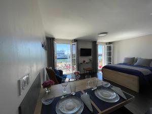 Cette chambre comprend un lit et une table avec des plaques de cuisson. dans l'établissement "L'ancre" Studio Perret Pleine vue mer, au Havre