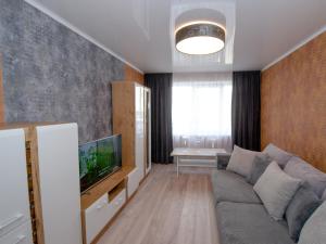 a living room with a couch and a tv at Jūras 4 Apartament in Ventspils