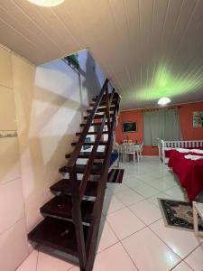 a spiral staircase in a living room with a table at Recanto da Vera in Ilhabela