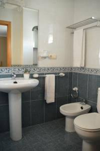 łazienka z umywalką, toaletą i lustrem w obiekcie Casa de Conde w mieście Coirón +19 zdjęć