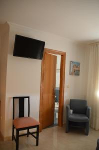 Pokój z krzesłem i telewizorem na ścianie w obiekcie Casa de Conde w mieście Coirón