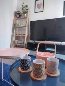 ein Wohnzimmer mit 3 Tassen auf dem Tisch in der Unterkunft Cocon avec jardin terrasse privé et parking in Brest