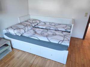 a bed in a room with a white wall at Ferienhaus Schwarzinger in Heinreichs bei Weitra